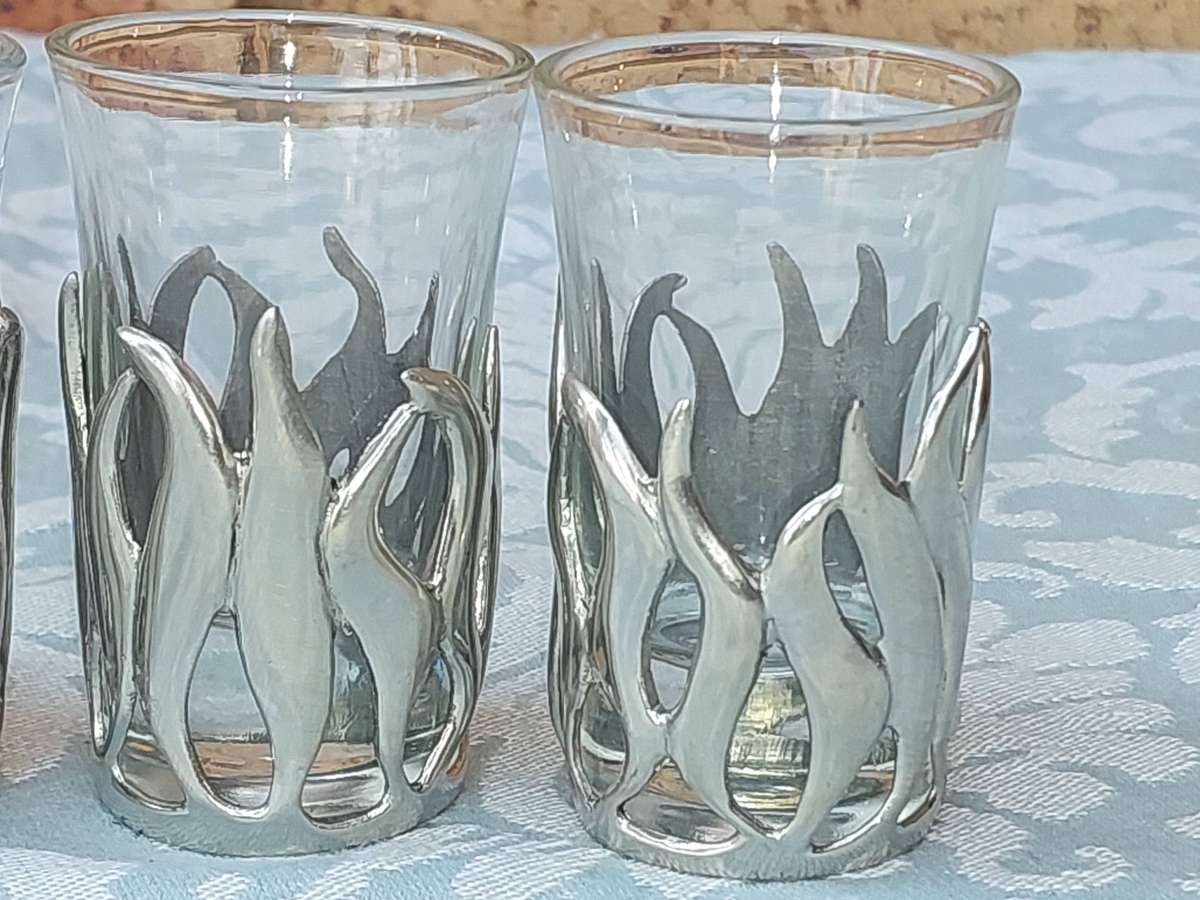 A SET OF SIX SHOT GLASSES WITH PEWTAL FALMES SOLD AS IS