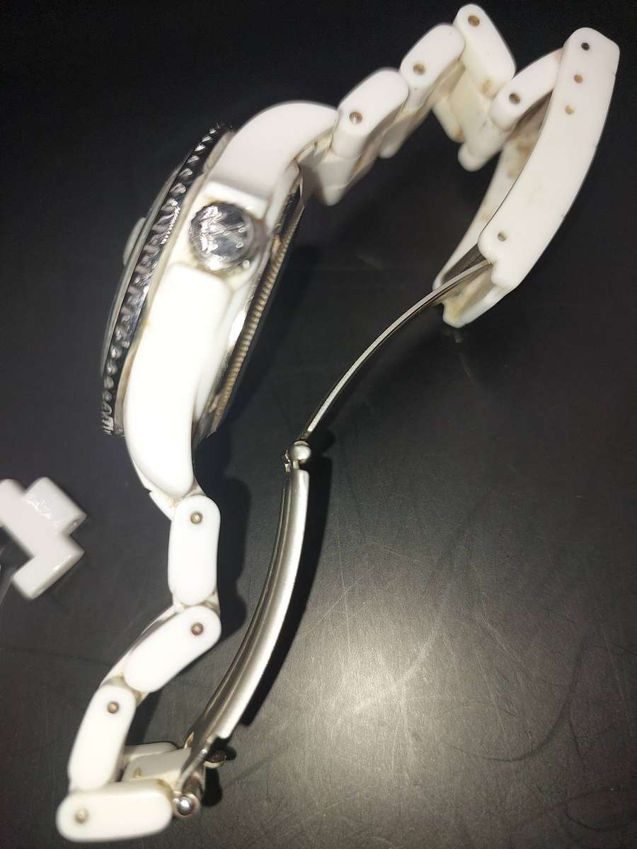A TOY WATCHE WHITE WITH STAINLESS STEEL CLIP AND BAZEL SOLD AS IS NOT TESTED