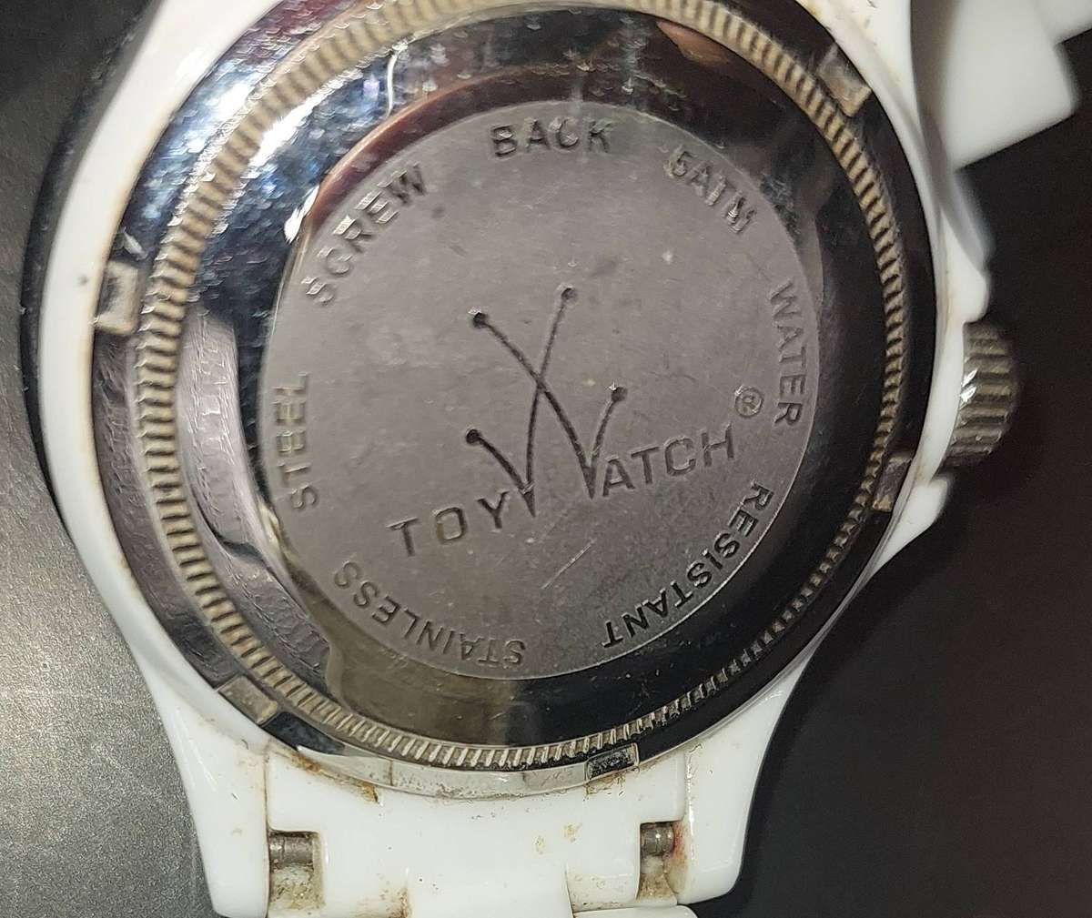A TOY WATCHE WHITE WITH STAINLESS STEEL CLIP AND BAZEL SOLD AS IS NOT TESTED