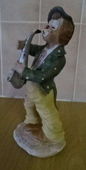 CERAMIC / PORCELAIN FIGURINE OF A HOBO CLOWN PLAYING SAXOPHONE  (+- 1984)
