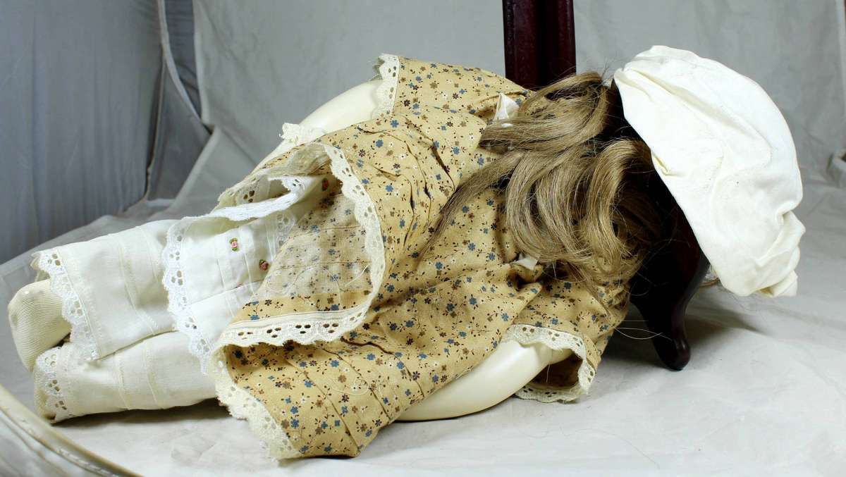 Vintage porcelain doll dressed in a period dress