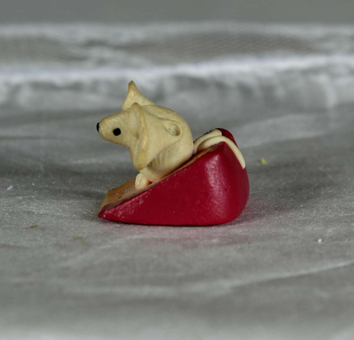 Mini miniature mouse on a slice of cheese