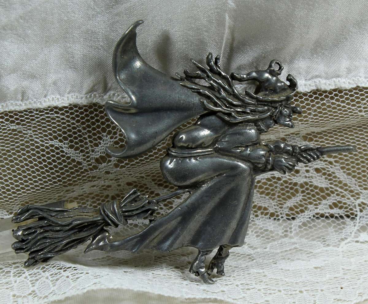 Large metal brooch of a witch with crystal