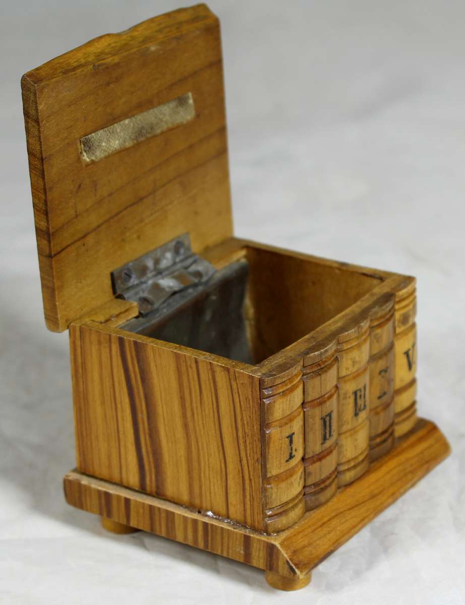 Small wooden box with carved books in front