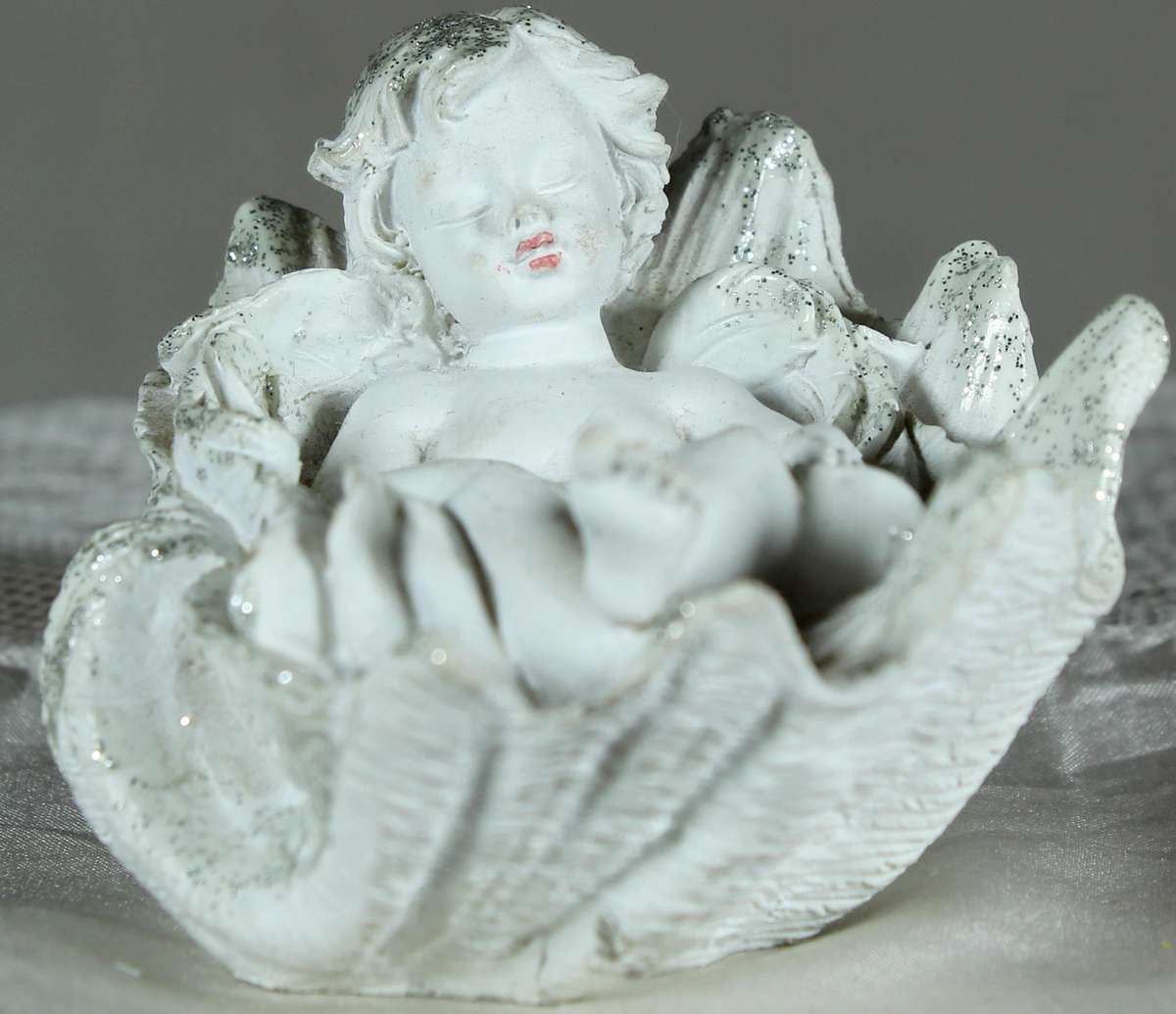 Little boy/angel laying in a large shell