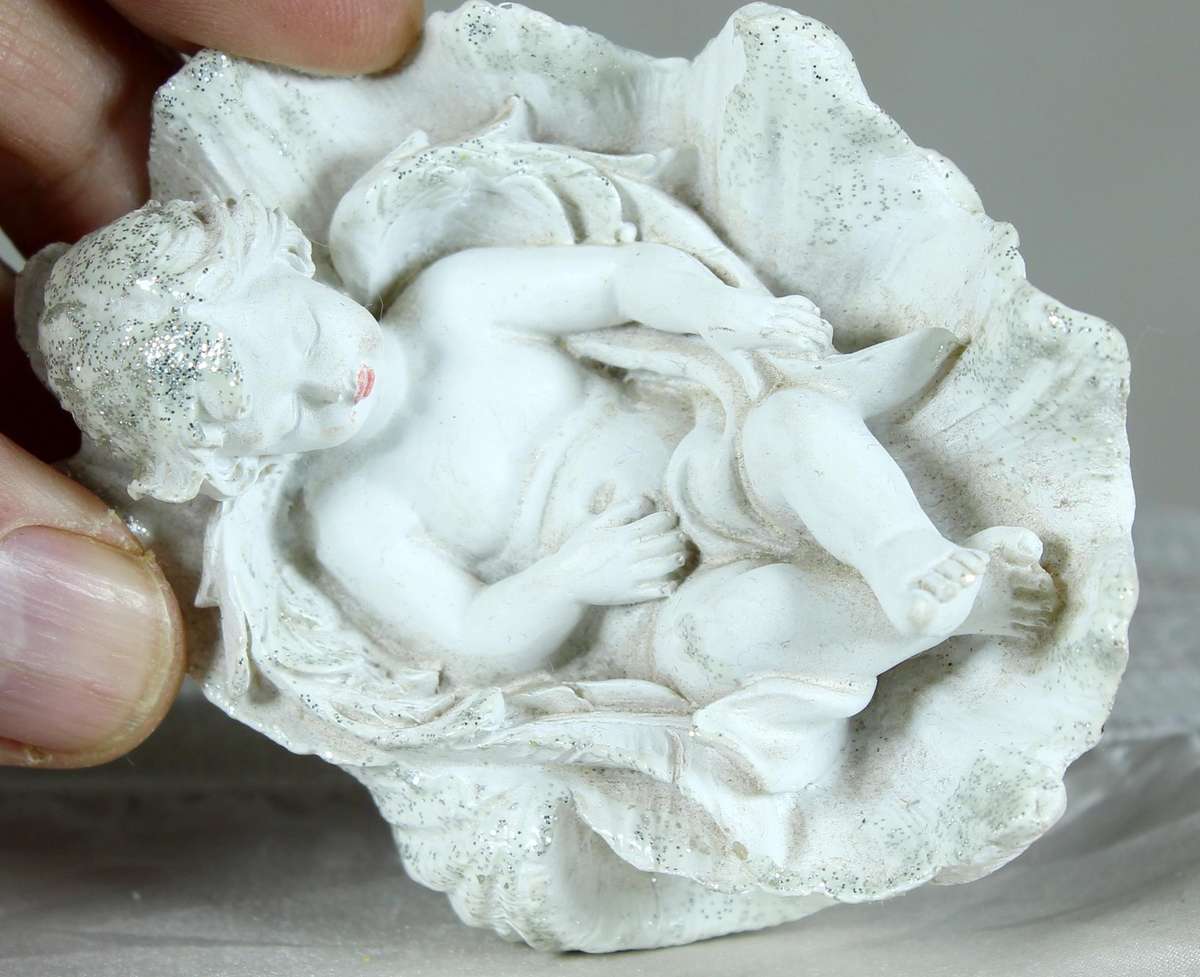 Little boy/angel laying in a large shell