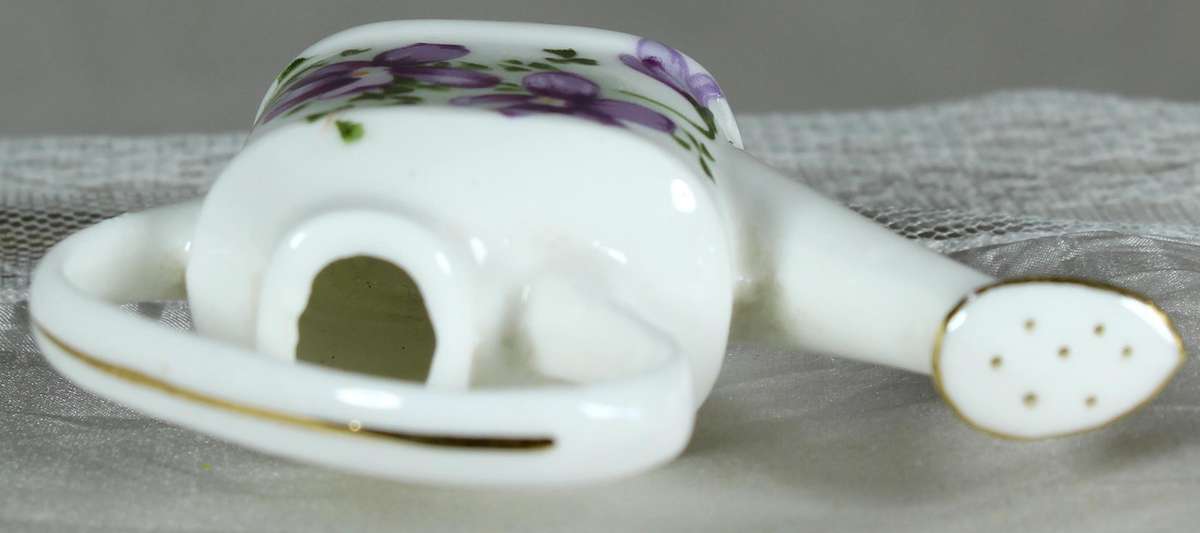 Miniature watering can with purple violets