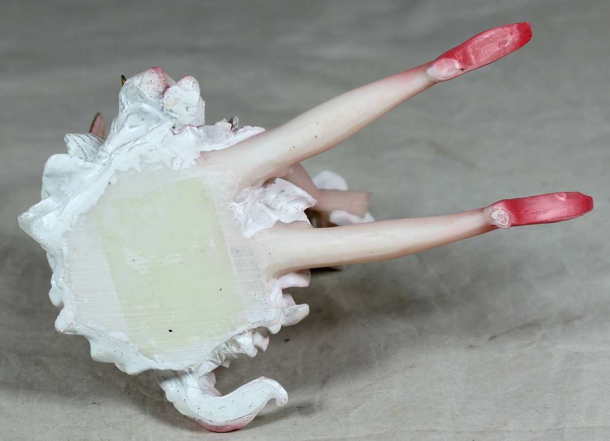 Seated ballerina in pink, holding a large flower