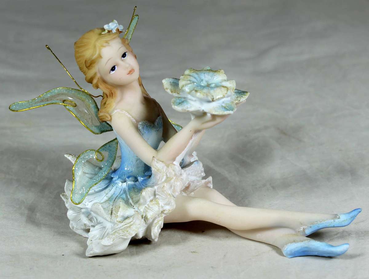 Seated ballerina in blue, holding a large flower