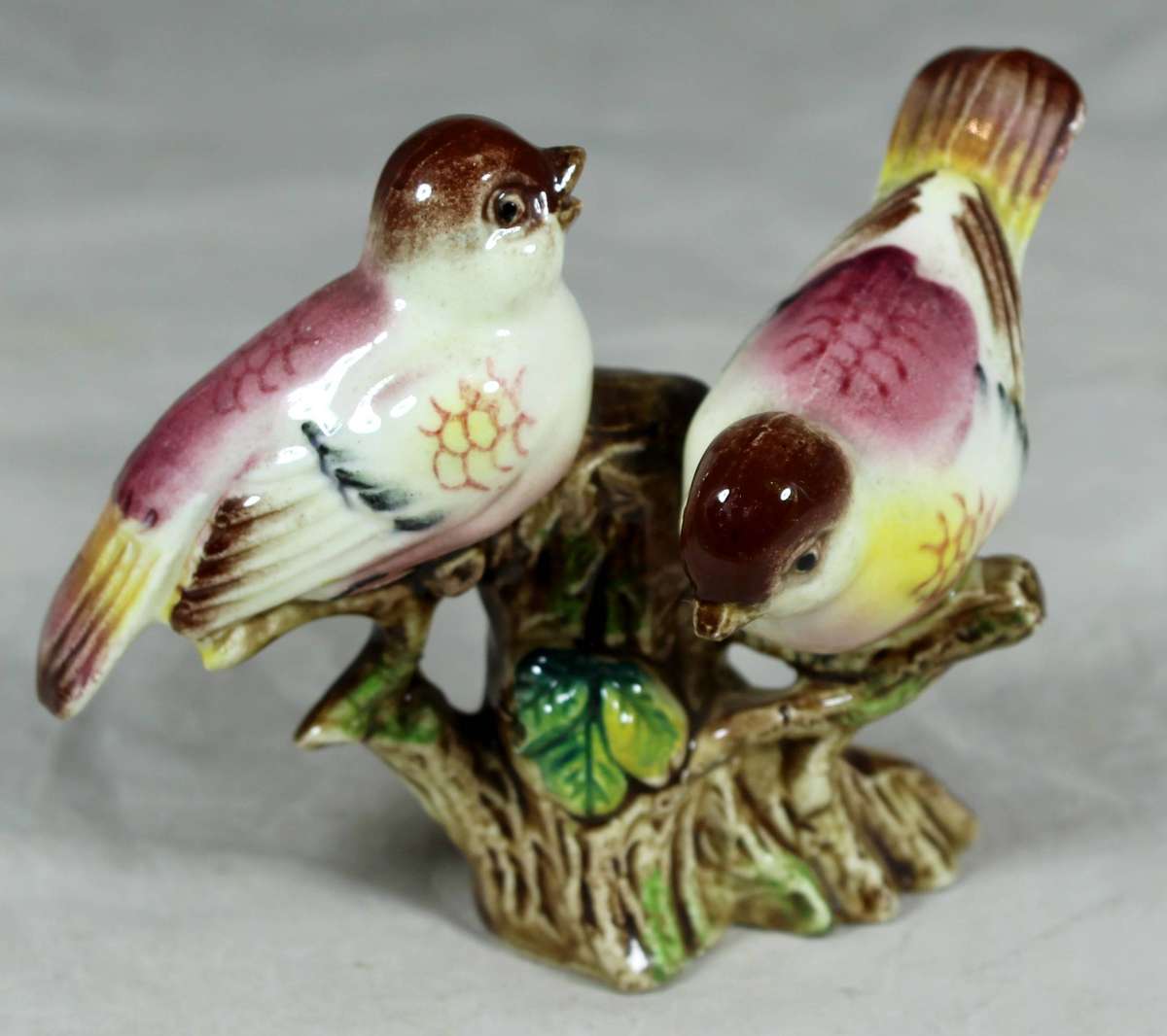 Pair of ceramic birds on a tree log