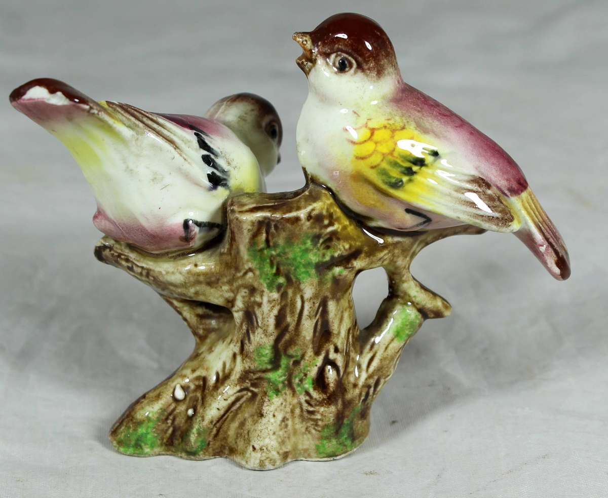 Pair of ceramic birds on a tree log