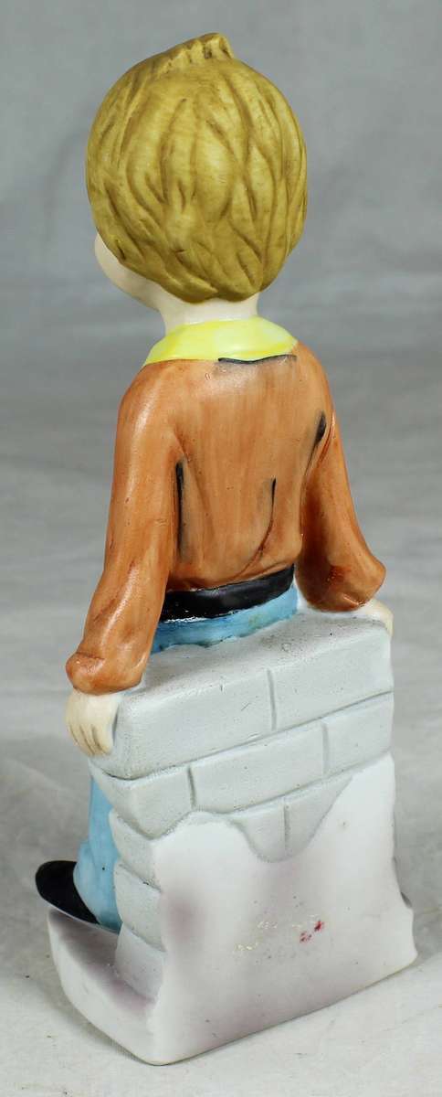 Ceramic school boy leaning against a wall