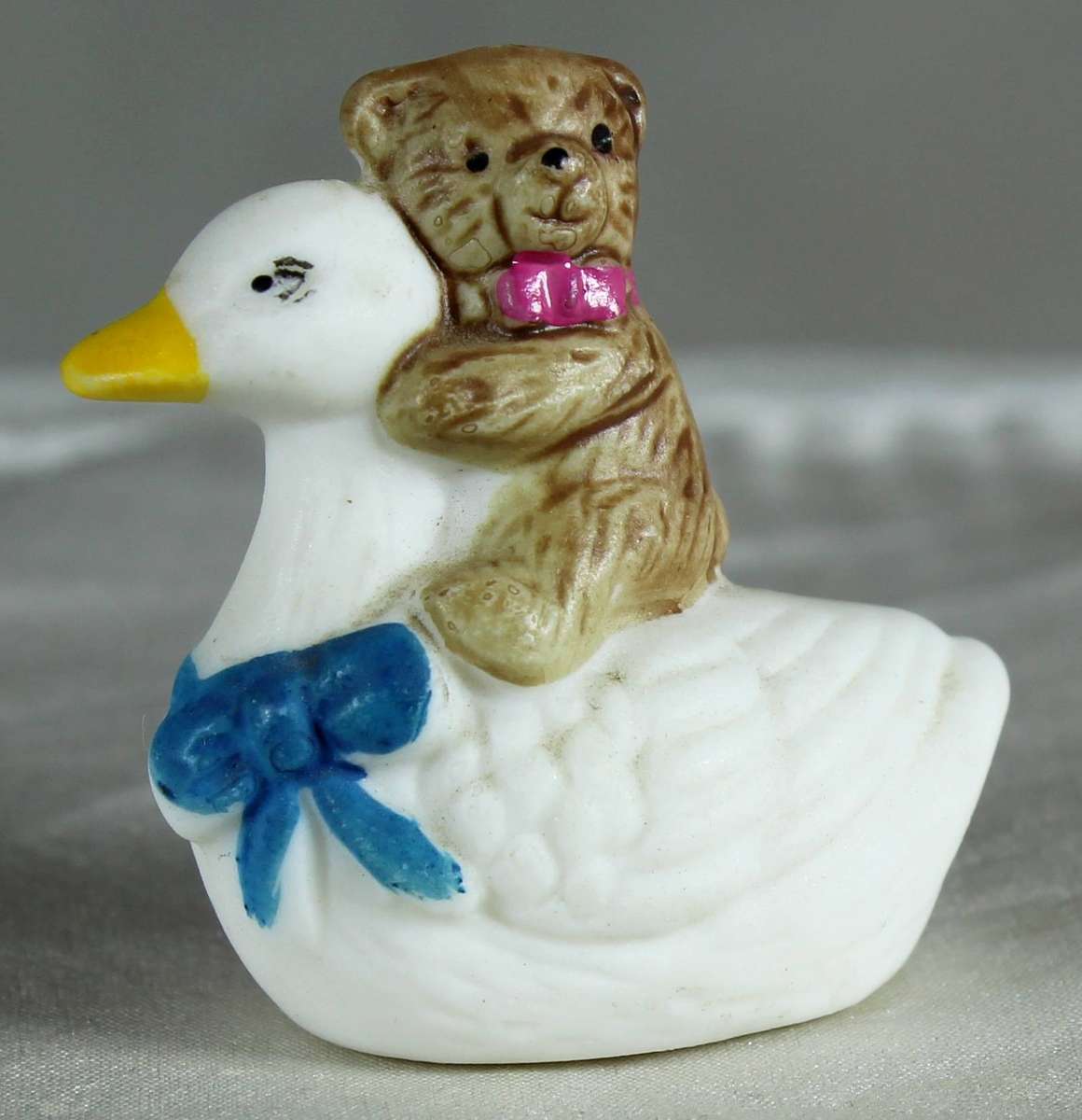 Miniature bear riding on a duck