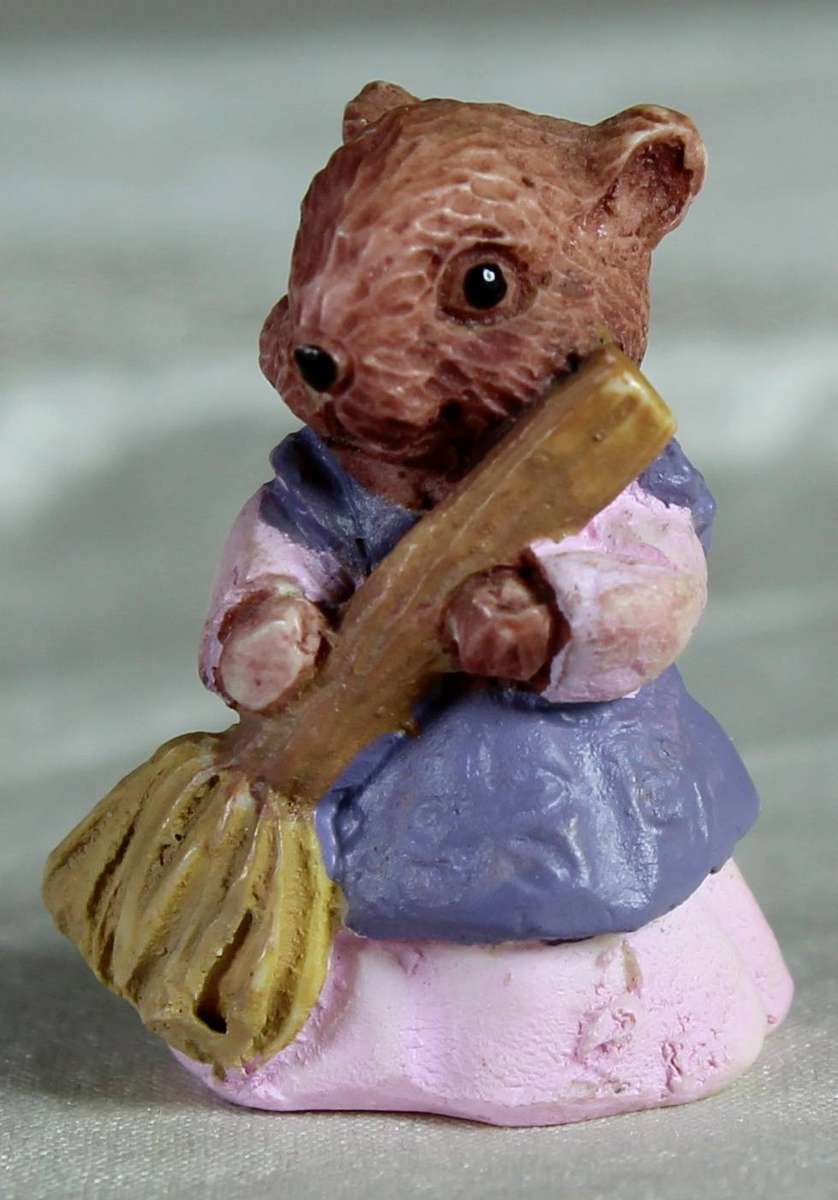 Mini miniature bear holding a broom in a pink dress