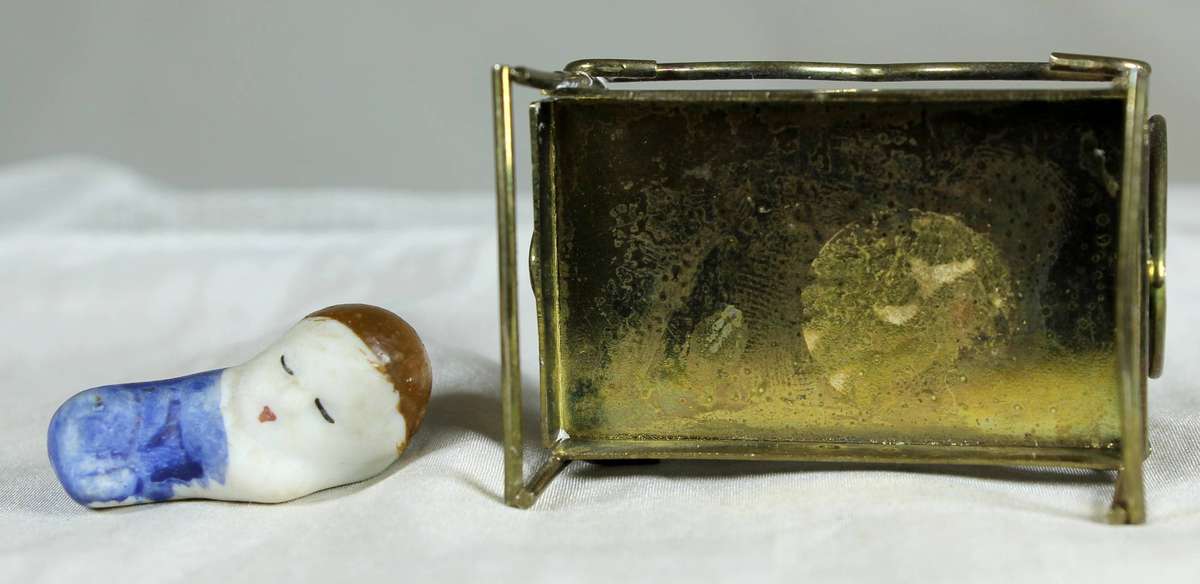 Mini miniature sleeping baby in a brass crib