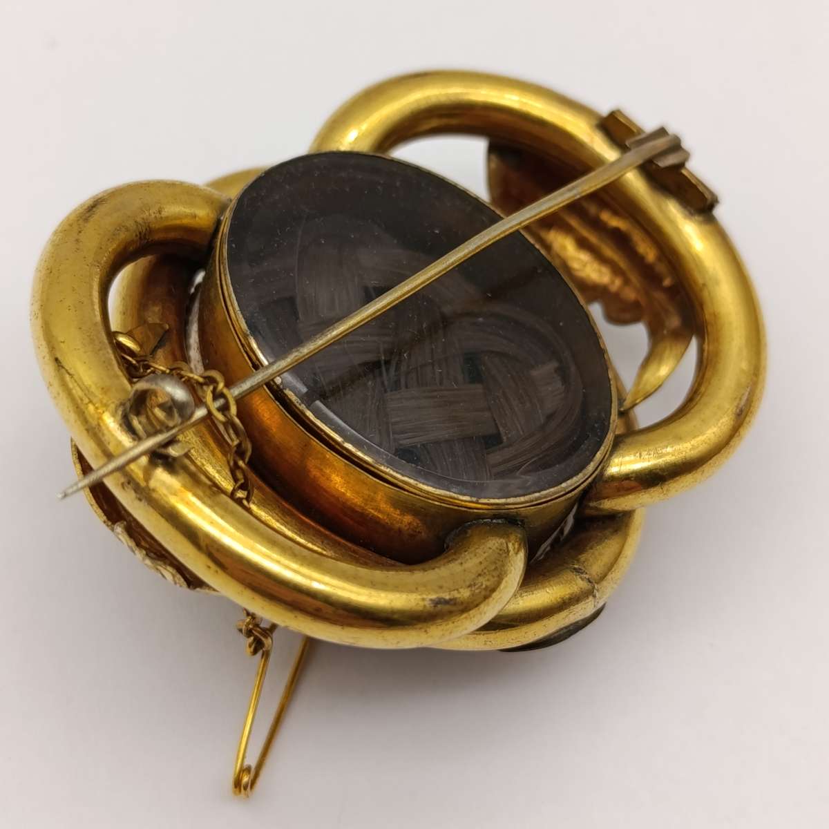 Antique low grade gold  mourning brooch with hair locket on back and safety chain