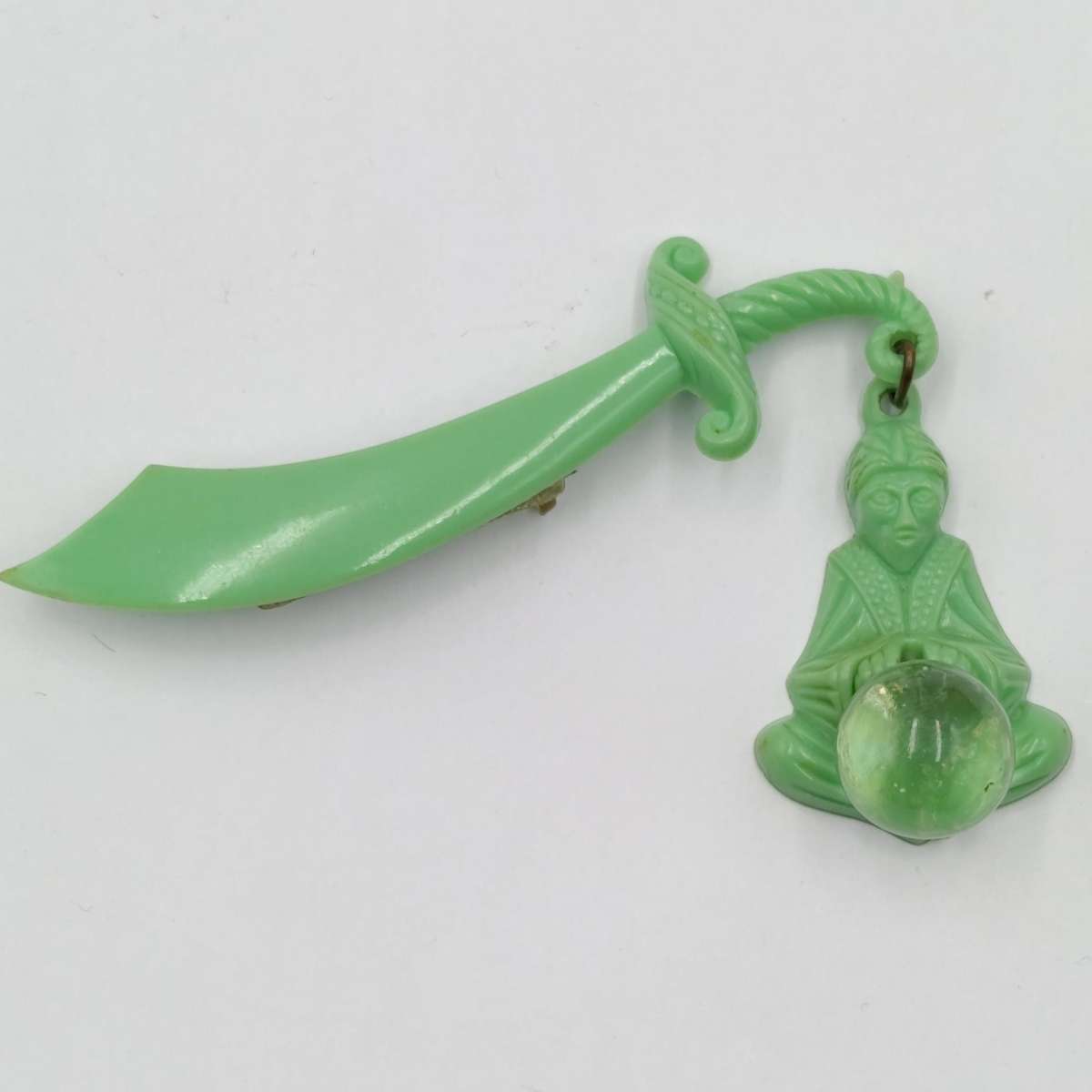 Green lucite brooch with sword and monk with crystal ball