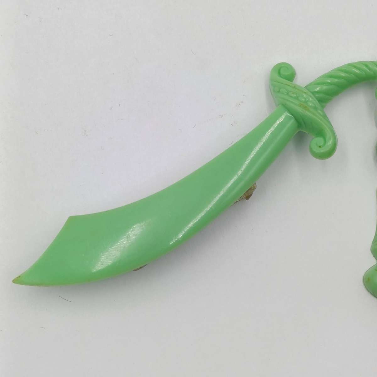 Green lucite brooch with sword and monk with crystal ball