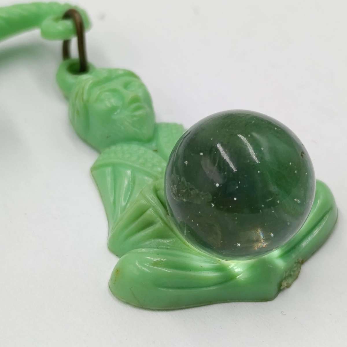 Green lucite brooch with sword and monk with crystal ball