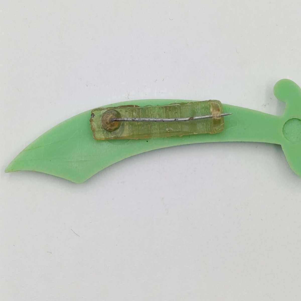 Green lucite brooch with sword and monk with crystal ball
