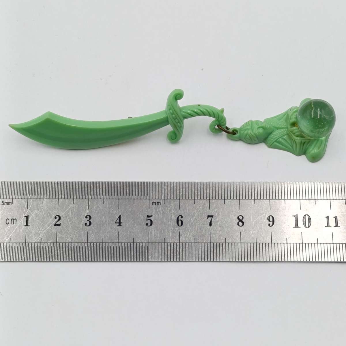 Green lucite brooch with sword and monk with crystal ball
