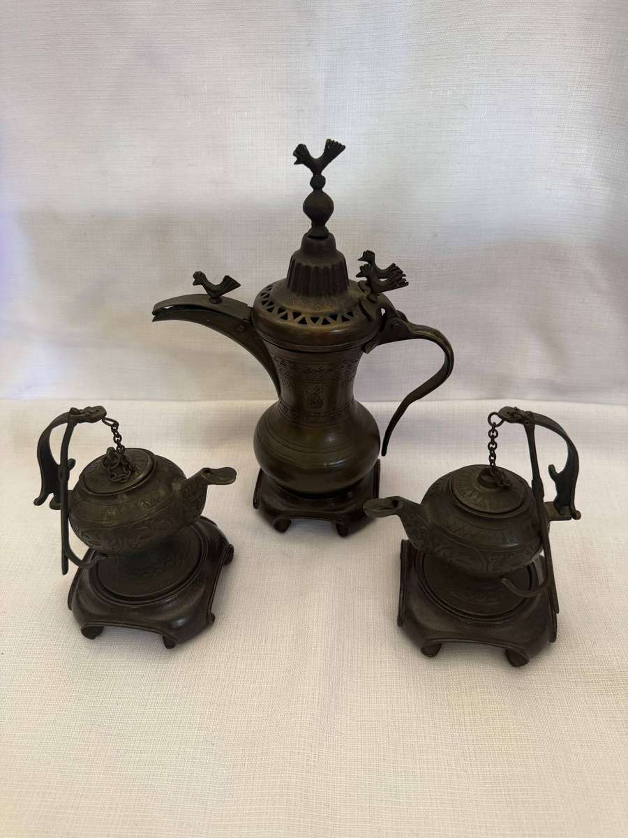 Three Turkish metal pots wit wooden stands