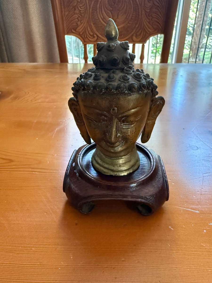 SMALL BUDDHA HEAD ON A WOODEN STAND
