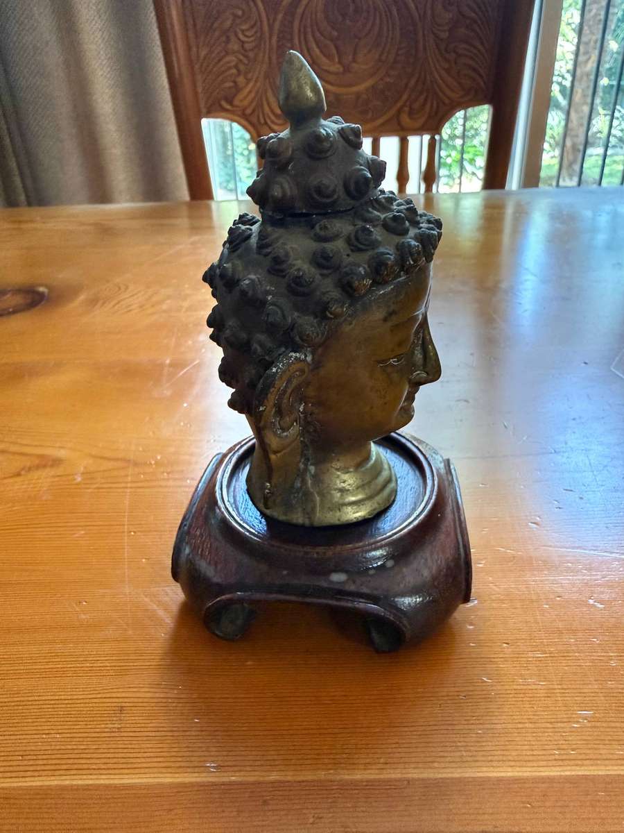 SMALL BUDDHA HEAD ON A WOODEN STAND