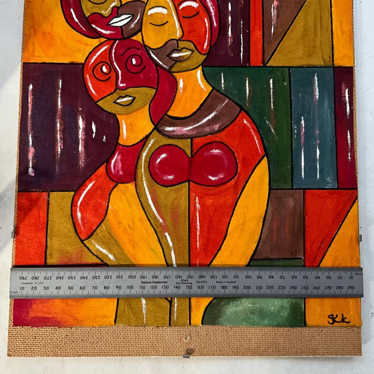 Colourful and bright painting on cloth of 3 people (family?) on abstract background