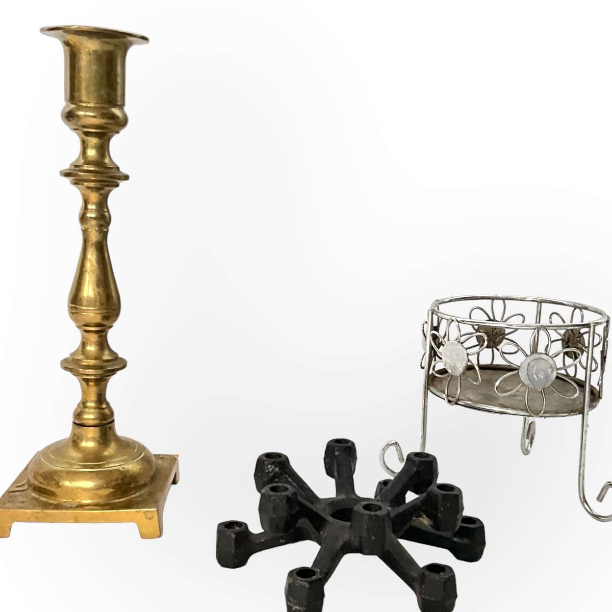 Three different styles of lighting- brass candlestick, Danish candleholder, modern floral tea light