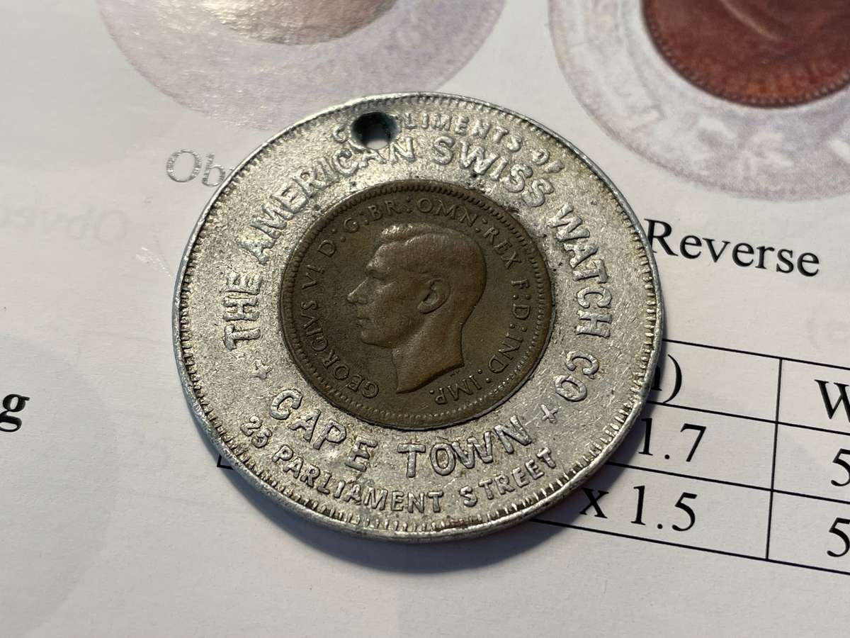 Scarce Cape Town good-luck token issued by a watch shop - Aluminium encased British farthing of 1938