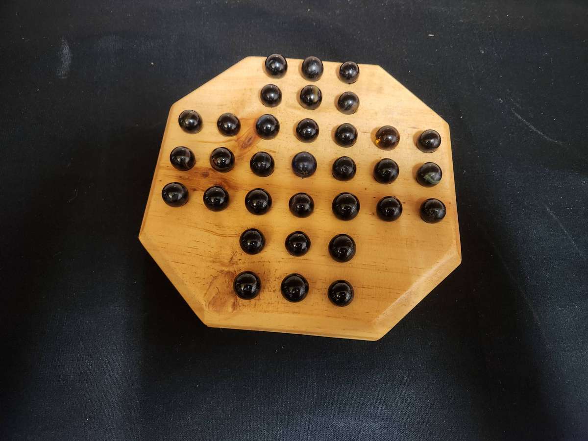 MARBLE SOLITAIRE GAME ON A WOODEN BOARD