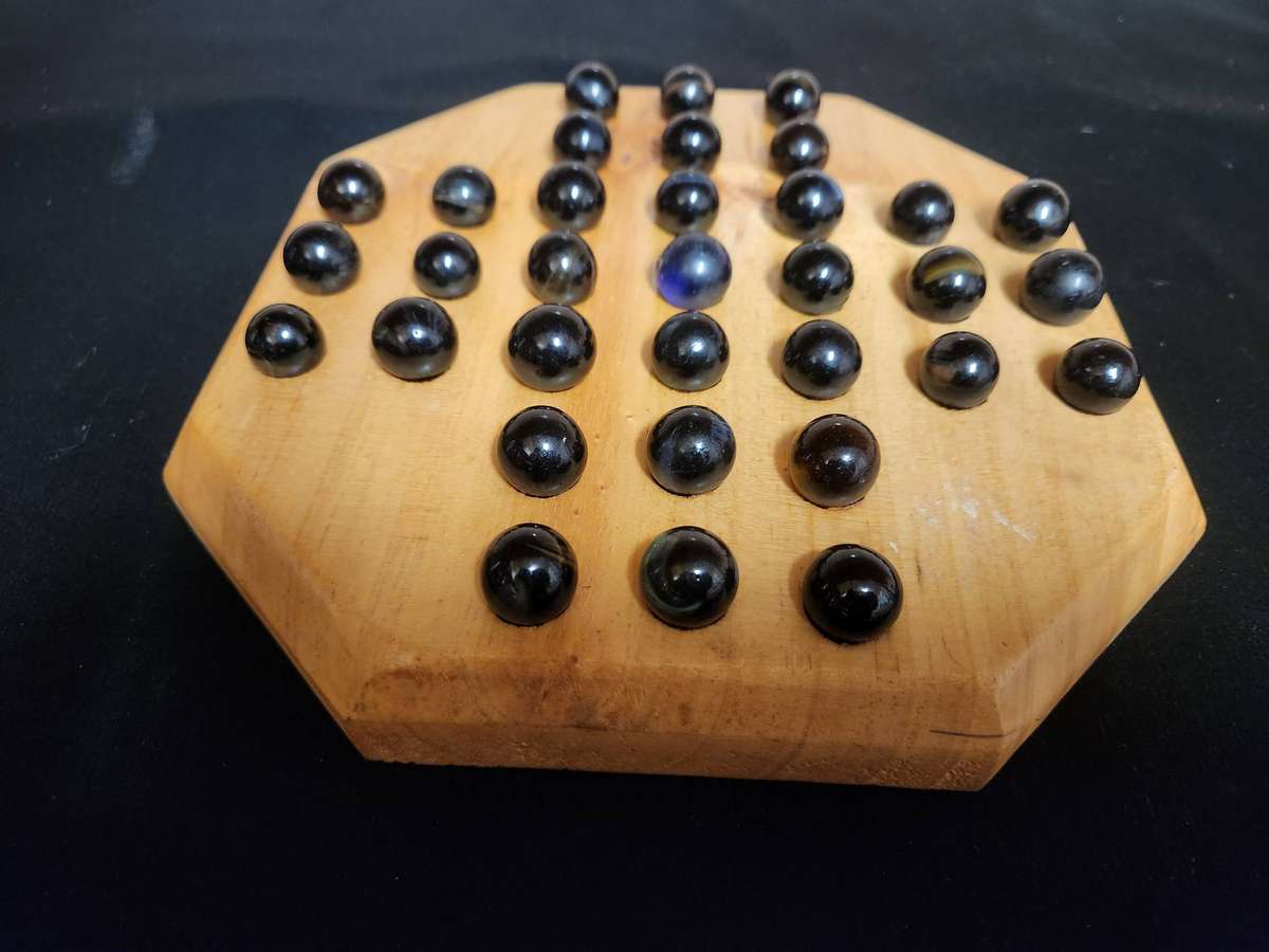 MARBLE SOLITAIRE GAME ON A WOODEN BOARD