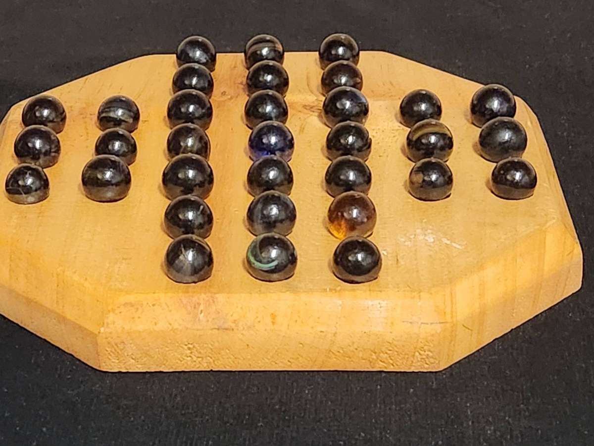MARBLE SOLITAIRE GAME ON A WOODEN BOARD