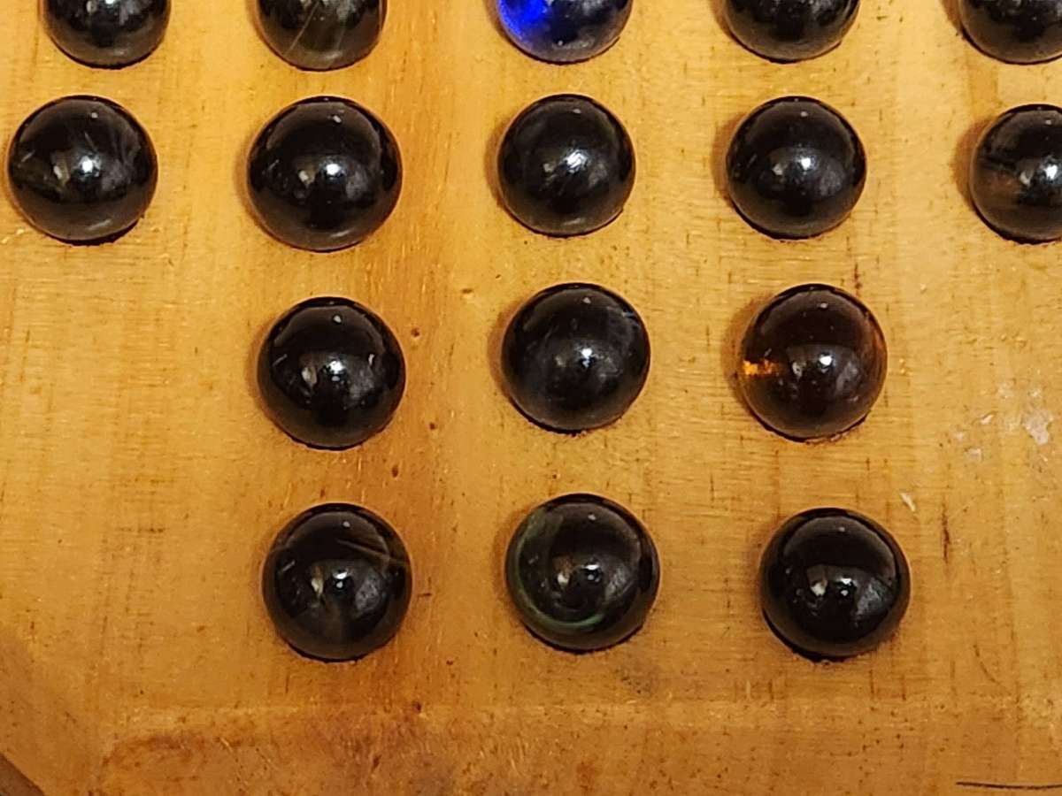 MARBLE SOLITAIRE GAME ON A WOODEN BOARD