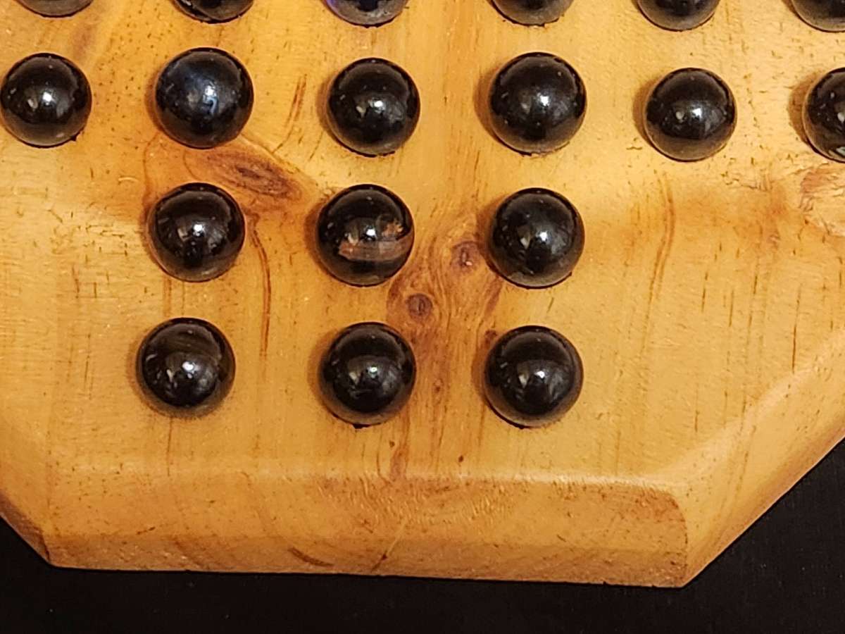 MARBLE SOLITAIRE GAME ON A WOODEN BOARD