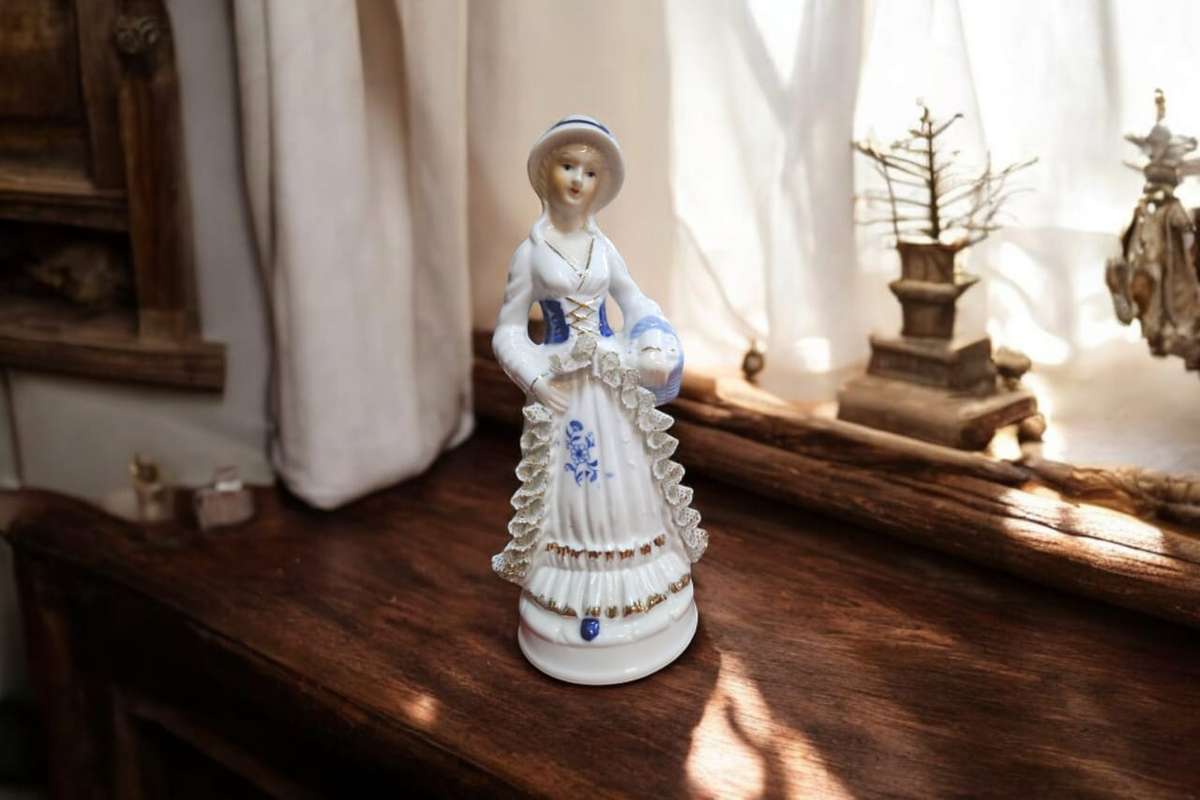 Exquisite vintage porcelain figurine of a Victorian lady. Standing at 20x7x7cm