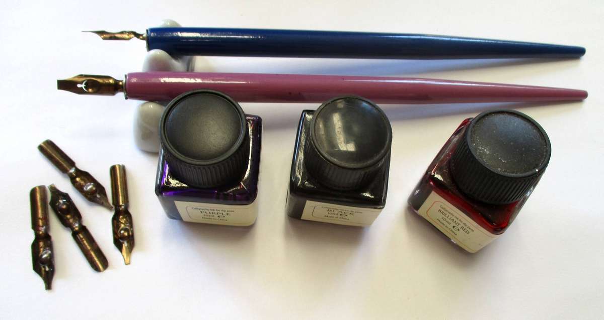 Calligraphy items - two pens and nibs, small inks and stand included.