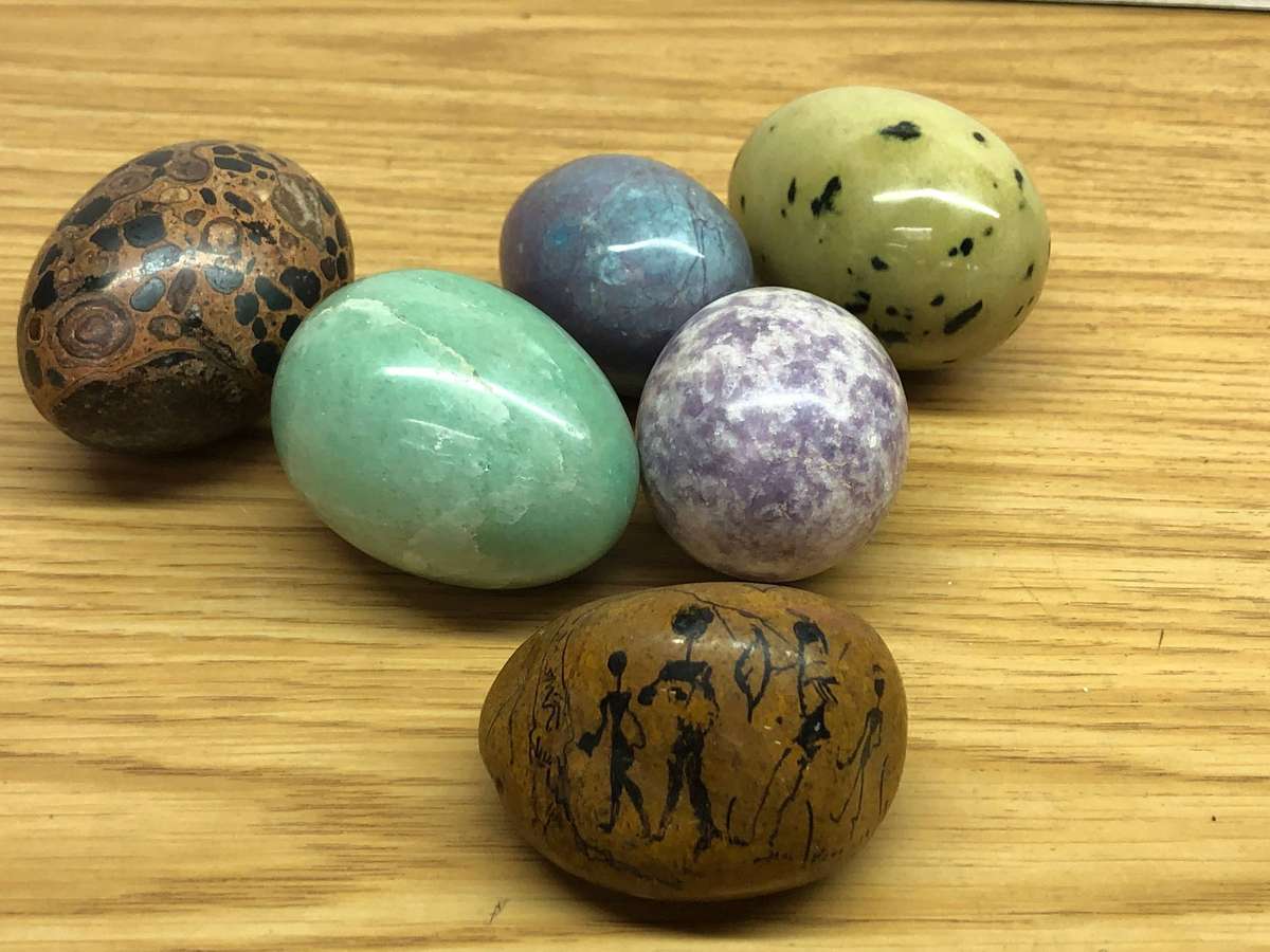 Collection of precious stone eggs and a bushmen painted rock