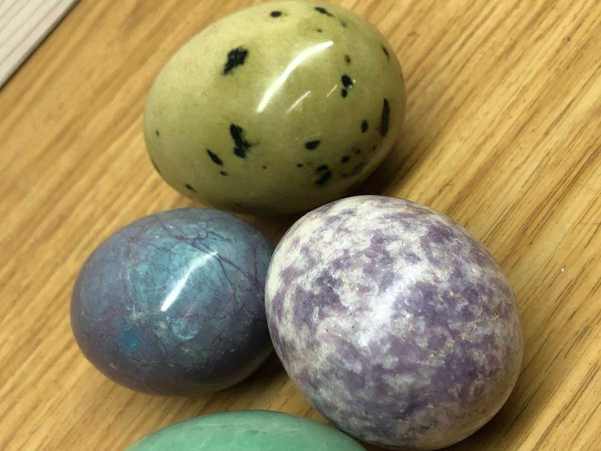Collection of precious stone eggs and a bushmen painted rock