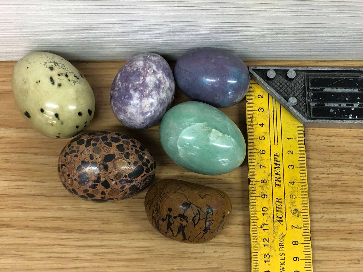 Collection of precious stone eggs and a bushmen painted rock