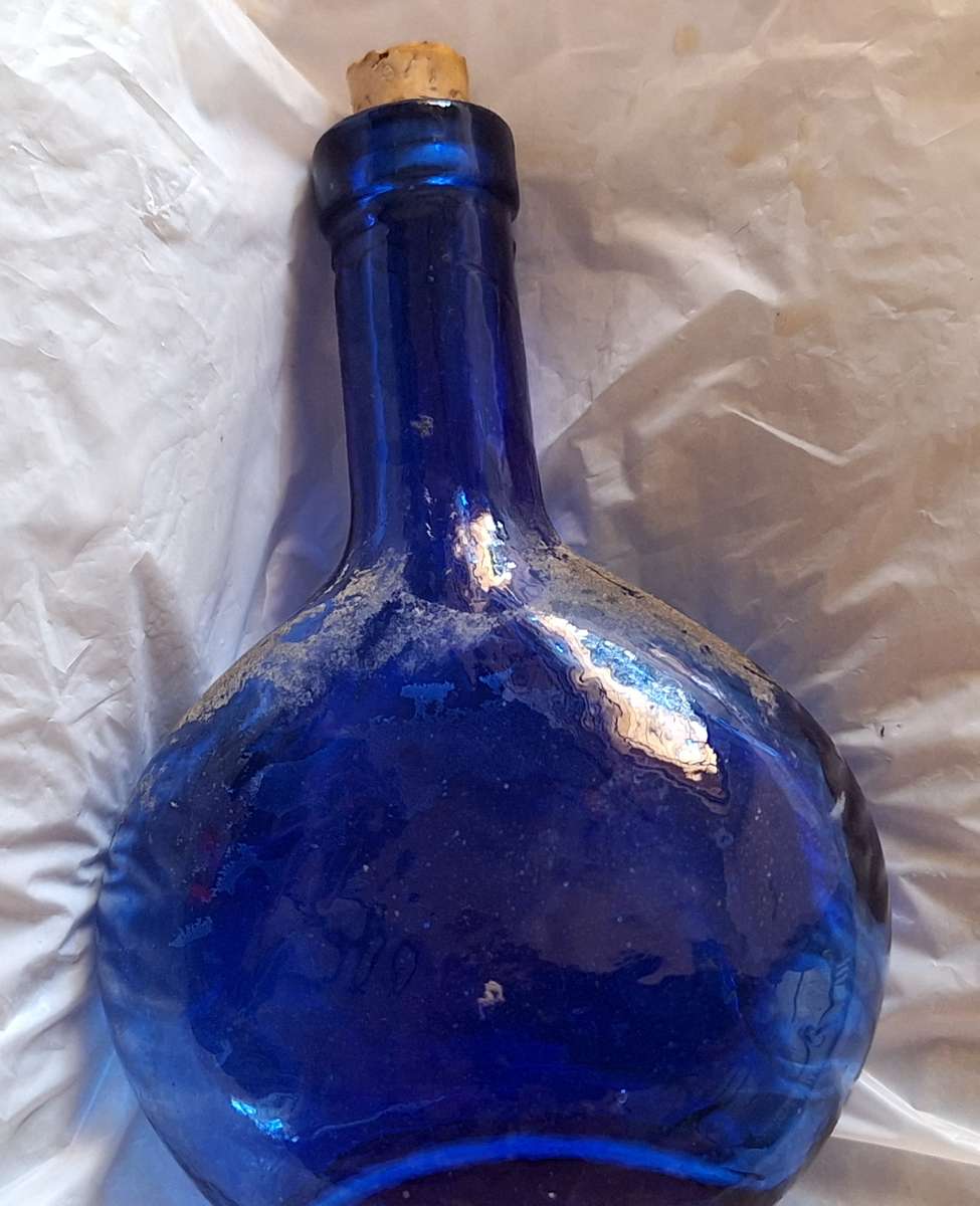 Small Blue Glass Bottle with Cork Stopper and Chip on Base