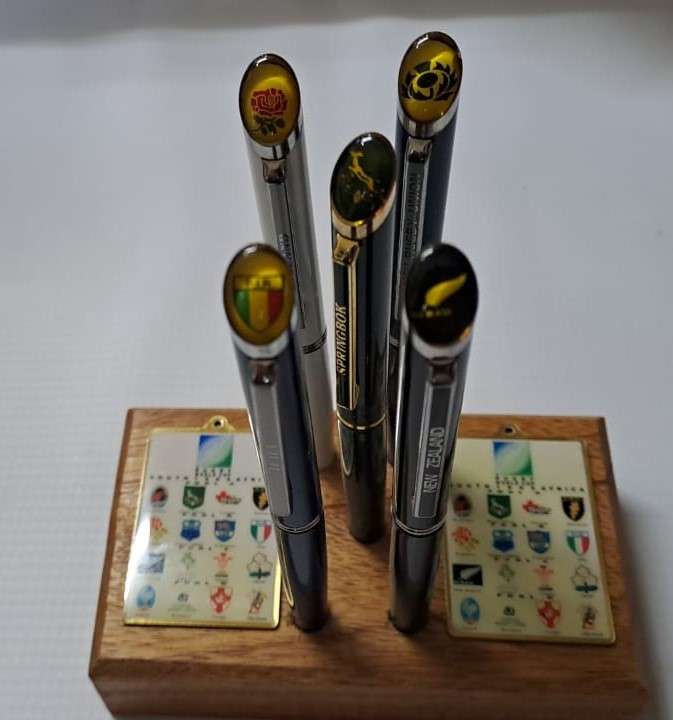 South Africa Rugby - 1995 WC 5 x Pens + 2 Keyrings on a wooden block. See description for collectors
