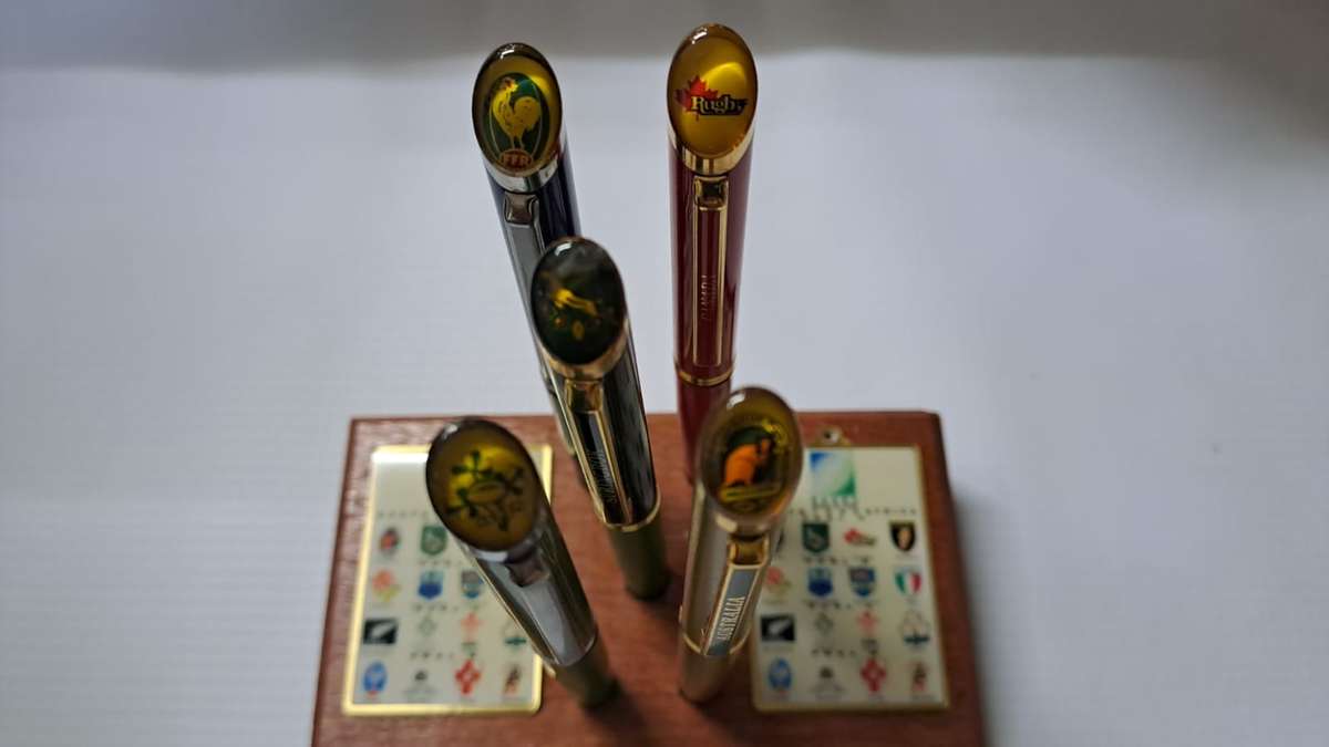 South Africa Rugby - 1995 WC 5 x Pens + 2 Keyrings on a wooden block.