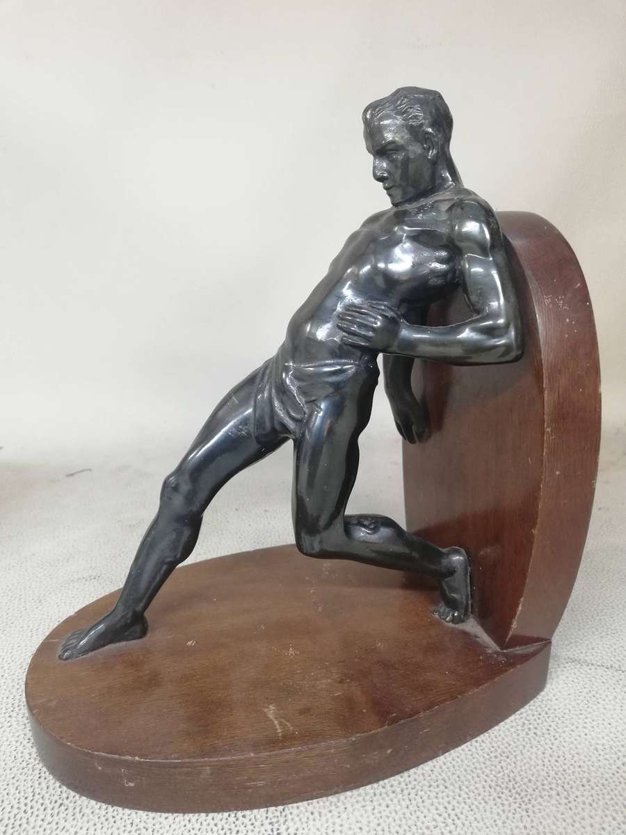 Vintage Bookend after R. Varmant, depicting a spelter leaning male athlete on a mahogany stand