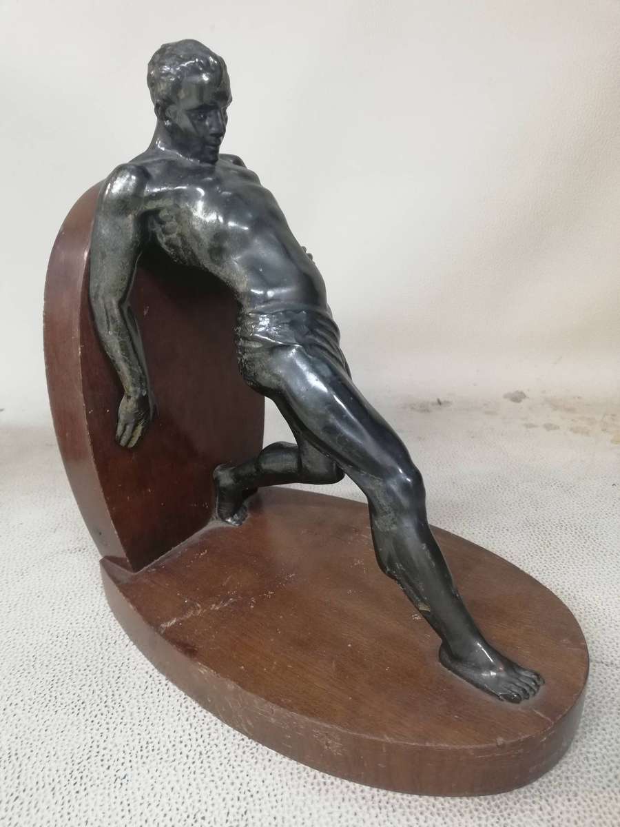 Vintage Bookend after R. Varmant, depicting a spelter leaning male athlete on a mahogany stand