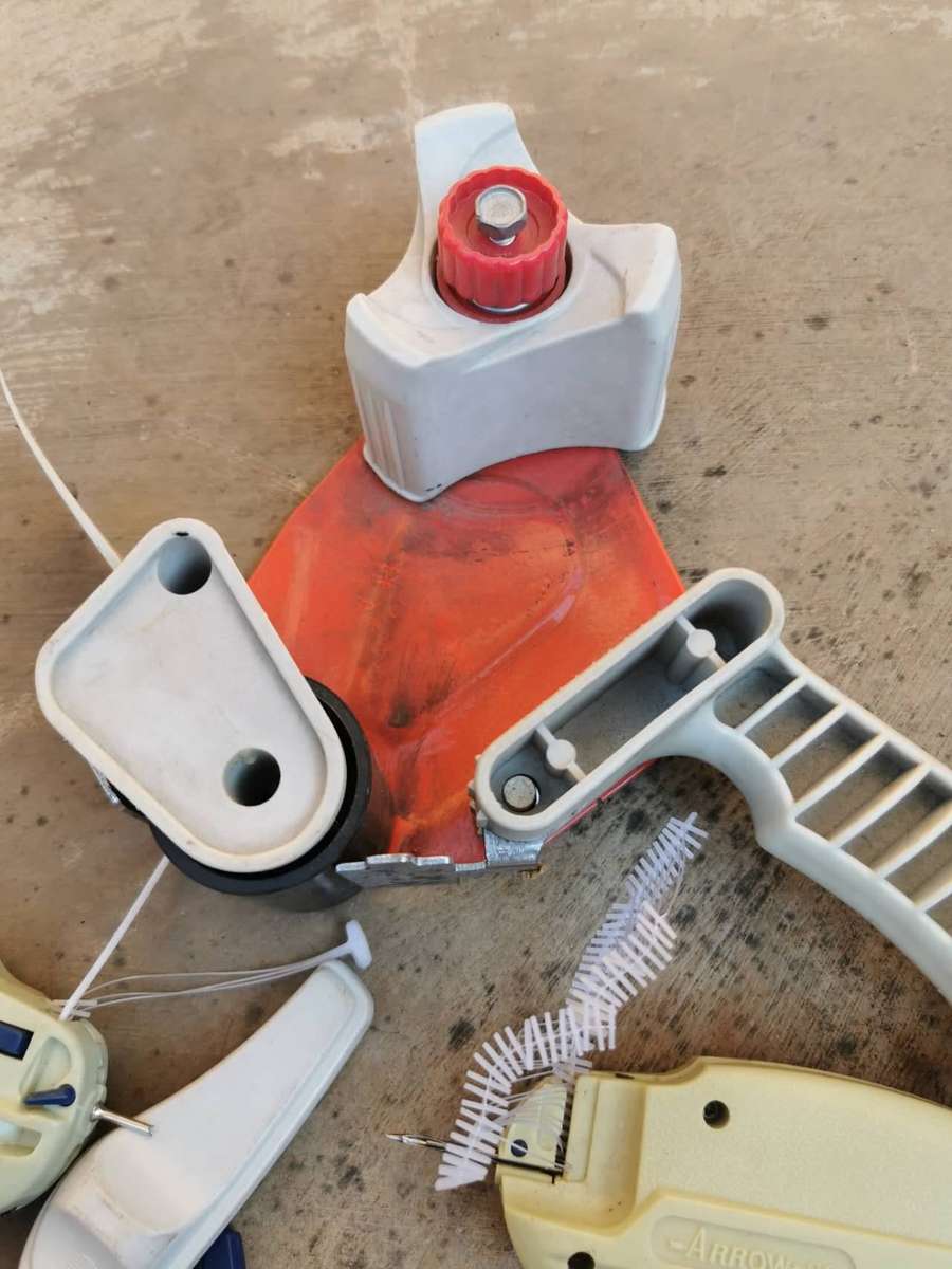 These are common retail packaging tools, including several tagging guns and a tape dispenser