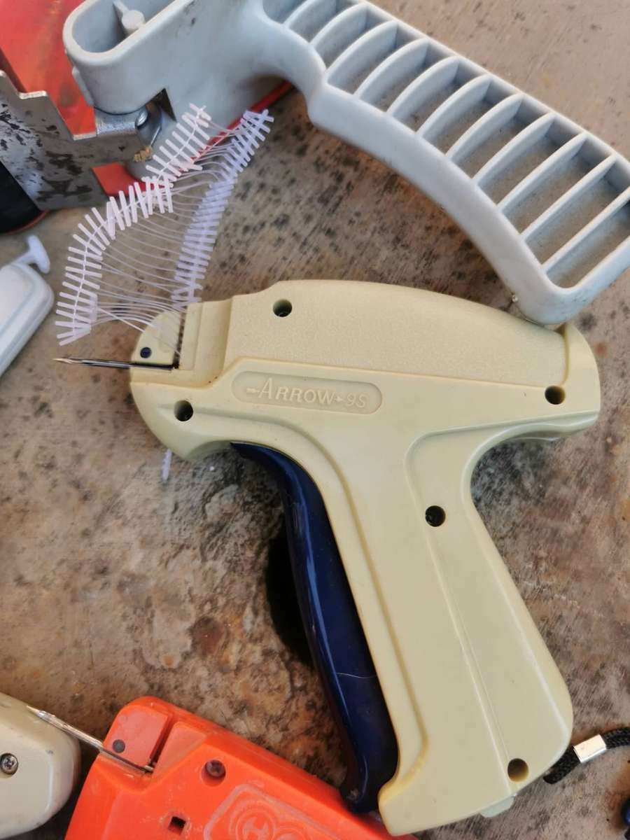 These are common retail packaging tools, including several tagging guns and a tape dispenser