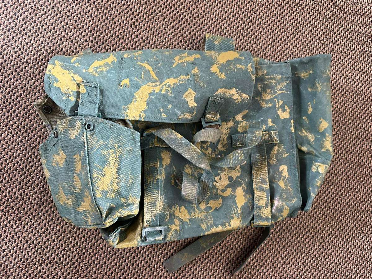 Rhodesian smaller back pack with water bottle side pouch and another open side pouch. measures 47x32