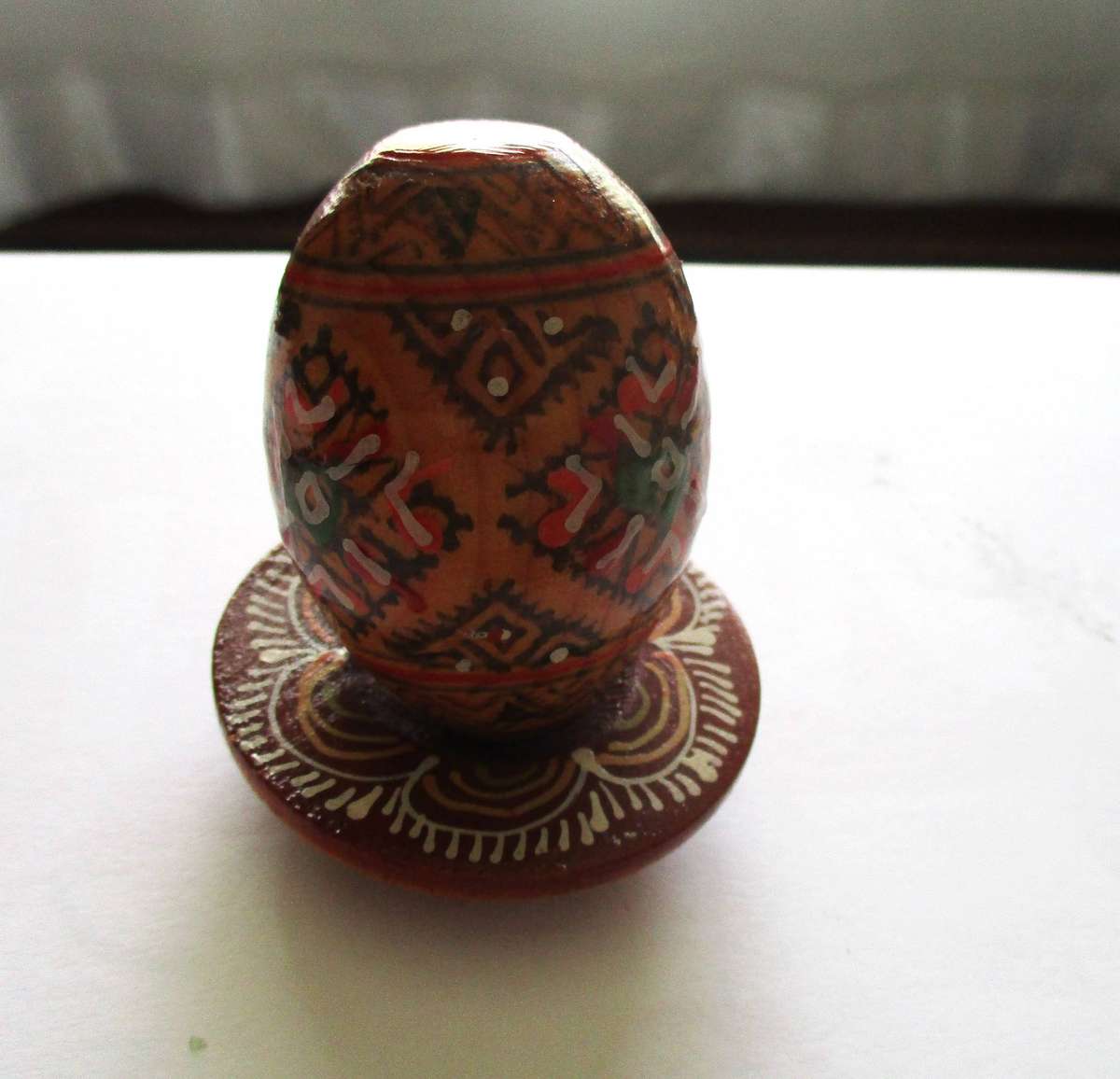 Stunning  painted wooden egg on a wooden stand
